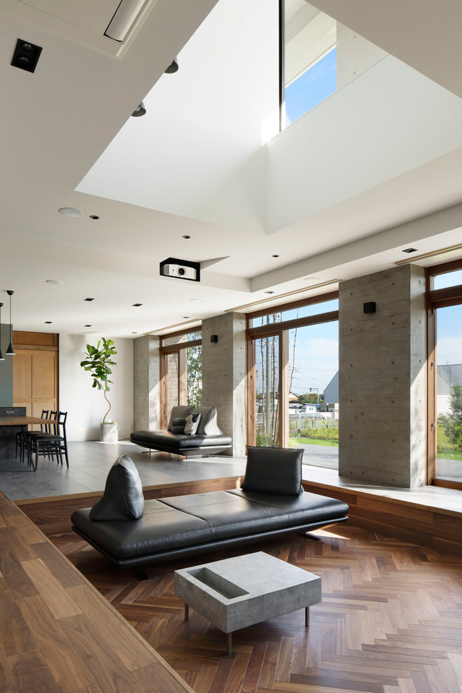 Ispirazione per un soggiorno moderno aperto con pareti bianche, pavimento in legno massello medio e pavimento marrone