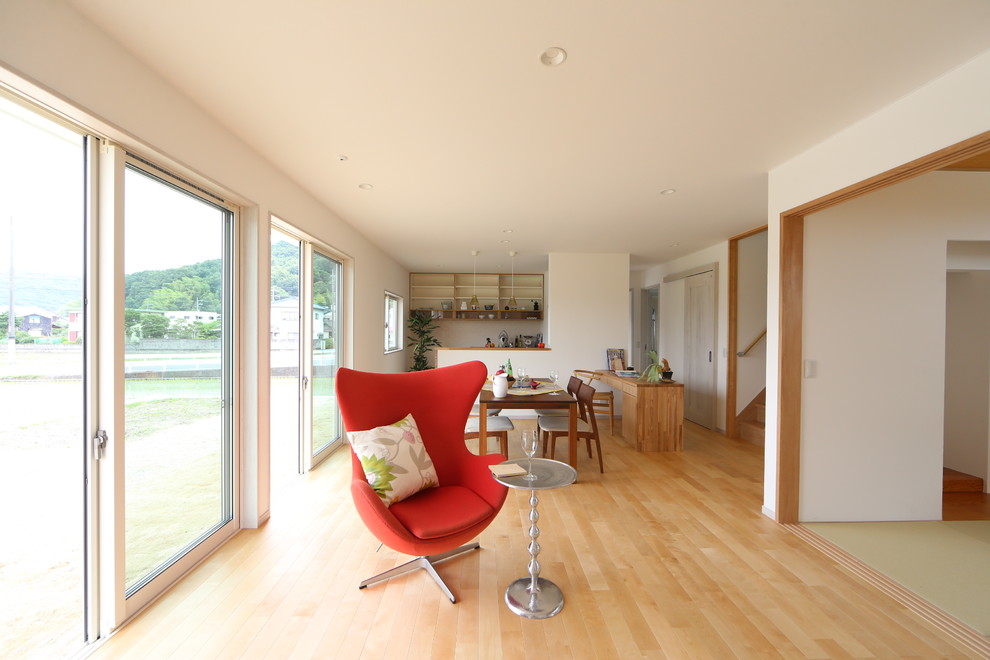 На фото: гостиная комната в стиле модернизм с белыми стенами, светлым паркетным полом и коричневым полом