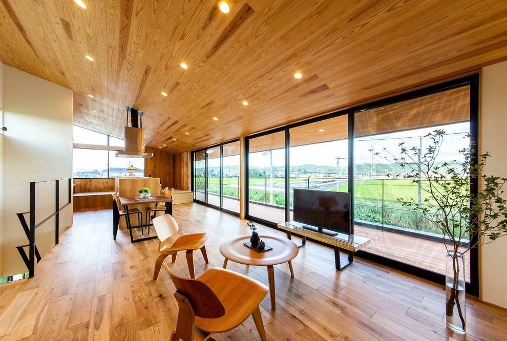 Esempio di un grande soggiorno minimal aperto con pareti marroni, pavimento in legno massello medio, TV autoportante e pavimento marrone