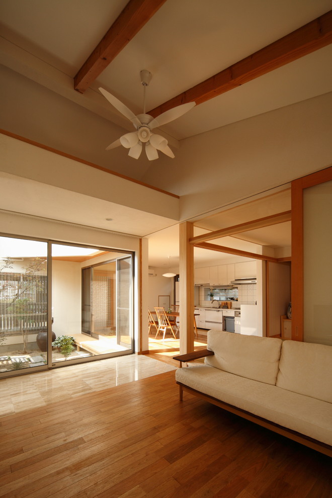 Asiatisches Wohnzimmer mit weißer Wandfarbe und braunem Boden in Sonstige
