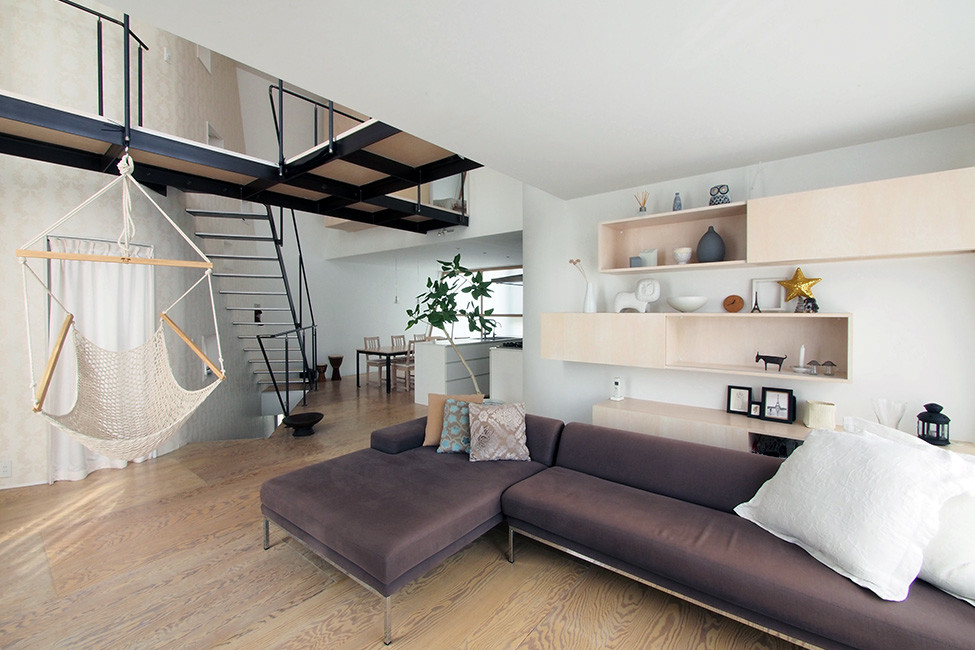 Идея дизайна: открытая гостиная комната среднего размера в стиле модернизм с белыми стенами, полом из фанеры и телевизором на стене без камина