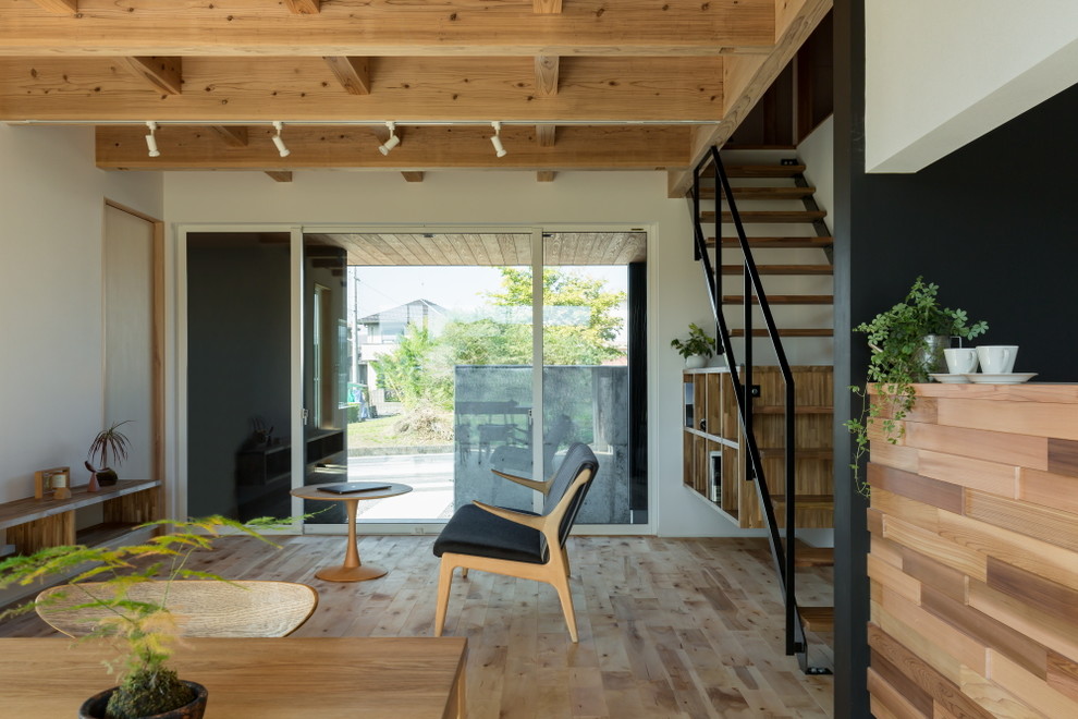 Asiatisches Wohnzimmer mit weißer Wandfarbe, hellem Holzboden und braunem Boden in Sonstige