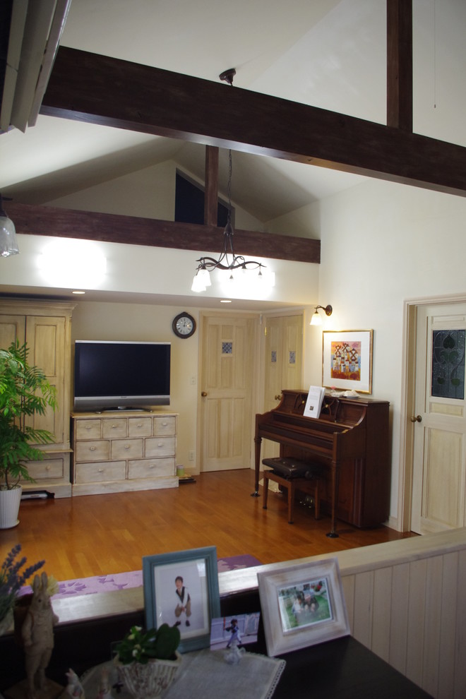 Immagine di un soggiorno country con pareti bianche, pavimento in legno massello medio e pavimento marrone