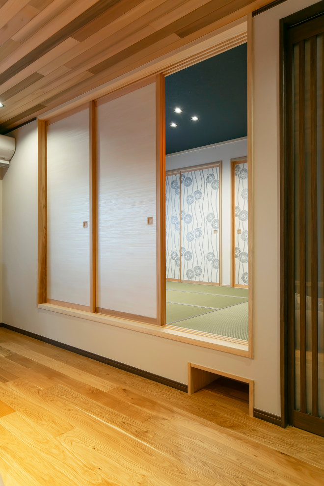 Asiatisches Wohnzimmer mit braunem Holzboden, Holzdecke und Tapetenwänden in Sonstige