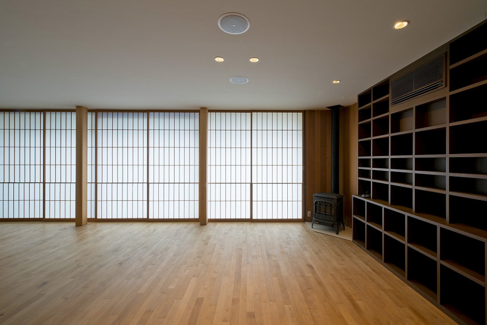 東京23区にある広いトラディショナルスタイルのおしゃれなLDK (ミュージックルーム、ベージュの壁、淡色無垢フローリング、コーナー設置型暖炉、木材の暖炉まわり、ベージュの床) の写真