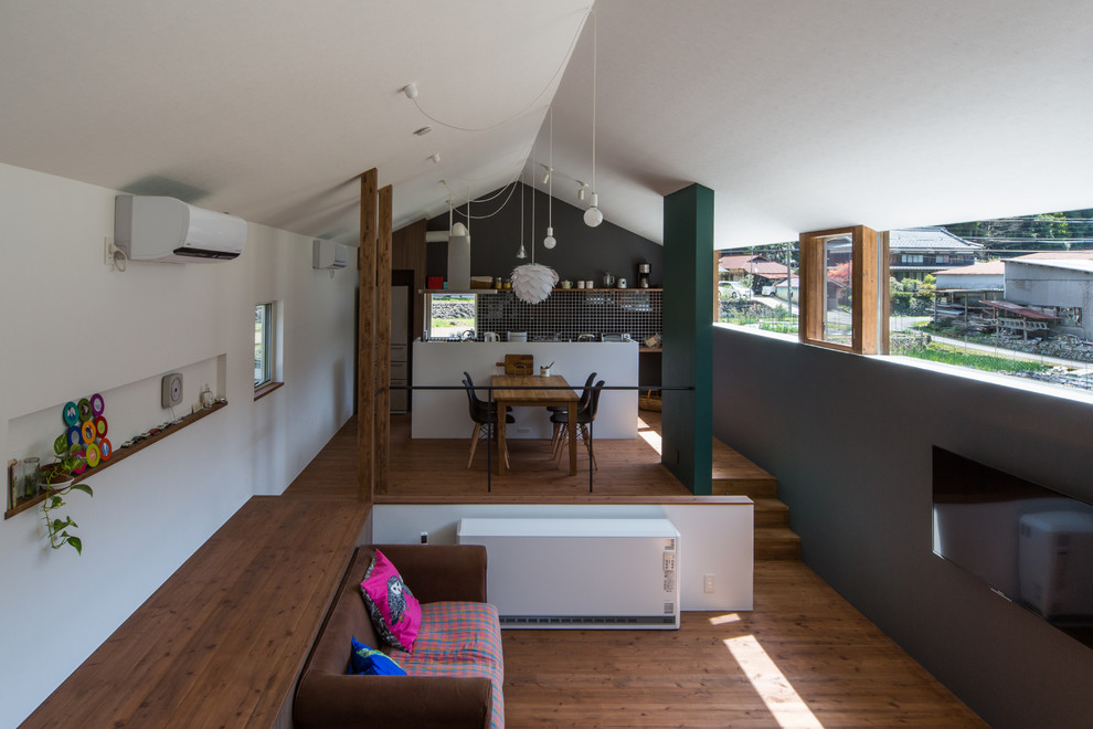 Идея дизайна: открытая гостиная комната в скандинавском стиле с белыми стенами, паркетным полом среднего тона и телевизором на стене