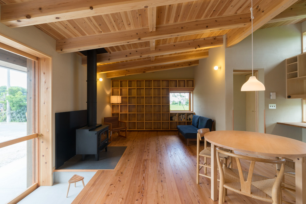 Esempio di un piccolo soggiorno rustico aperto con TV autoportante, pareti beige, pavimento in legno massello medio e pavimento marrone