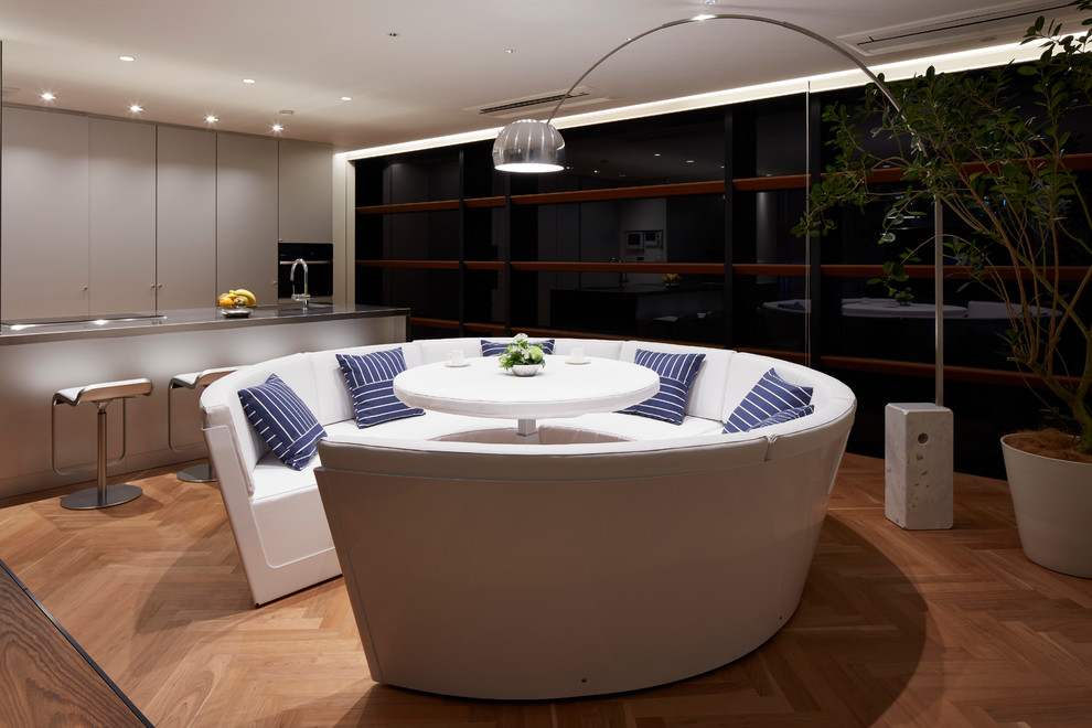 Diseño de salón abierto contemporáneo sin chimenea y televisor con paredes blancas y suelo de madera clara