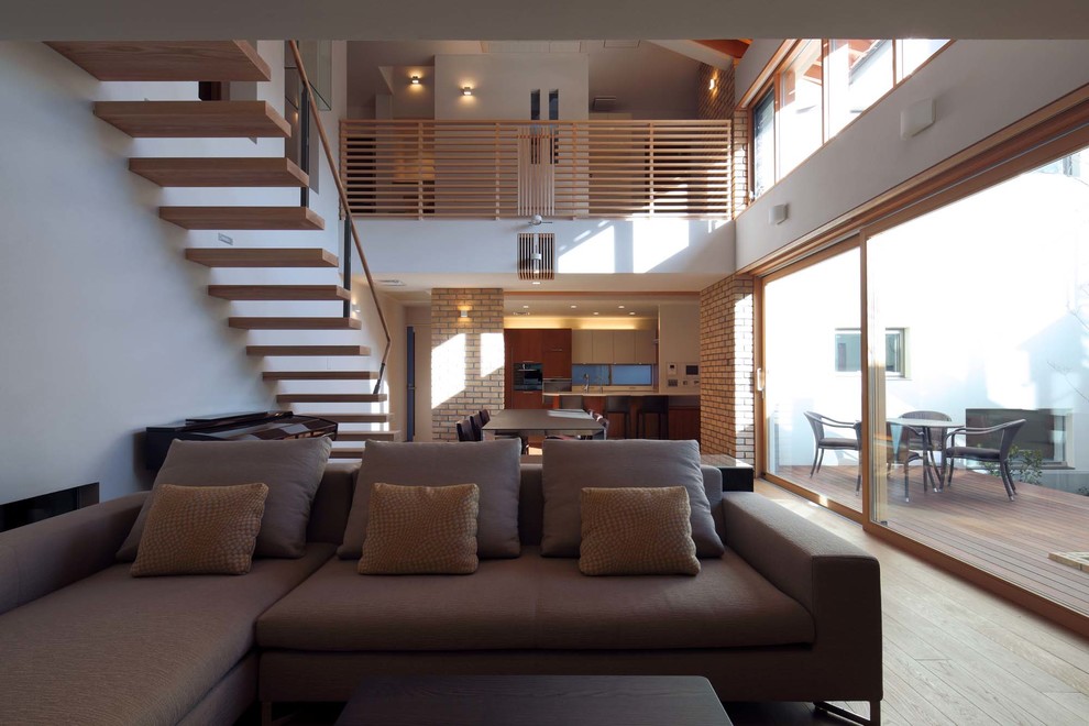 Стильный дизайн: открытая гостиная комната в современном стиле с белыми стенами и светлым паркетным полом без телевизора - последний тренд