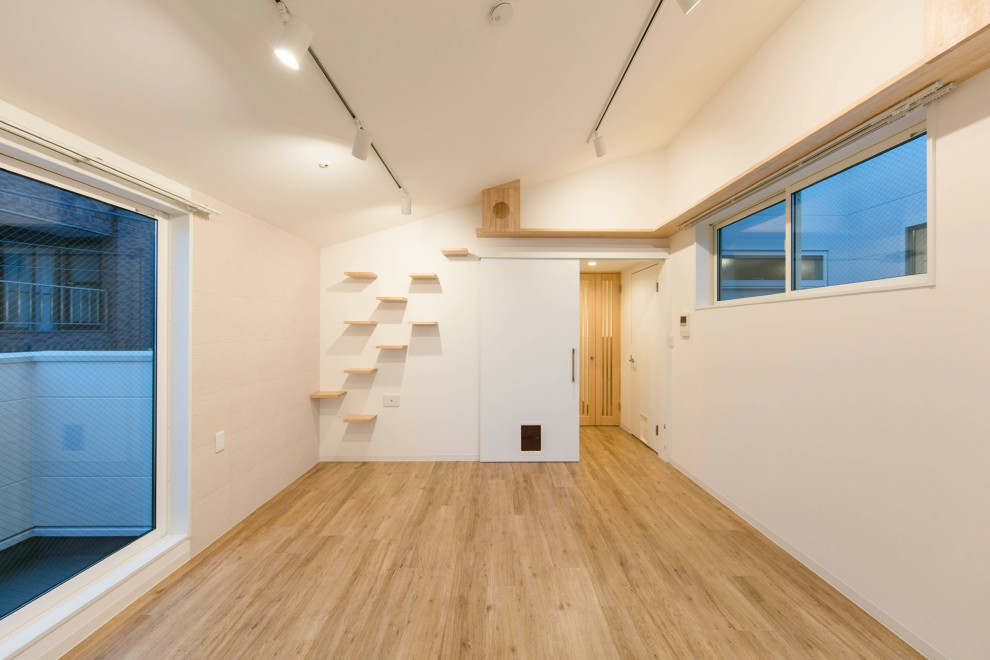 Ejemplo de salón abierto nórdico de tamaño medio con paredes blancas, suelo de madera clara, suelo beige, papel pintado y ladrillo
