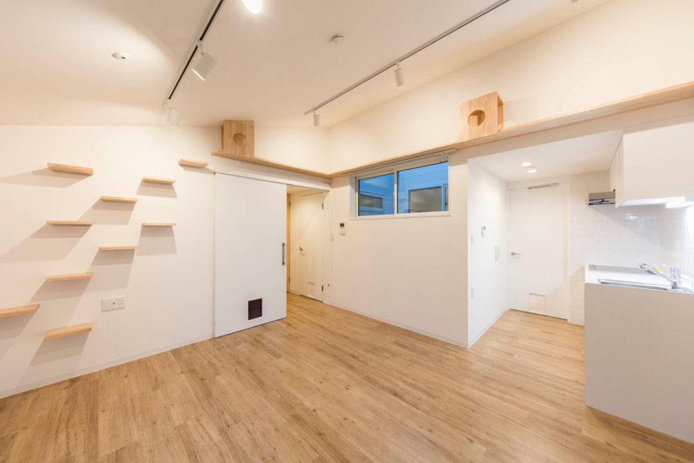 Foto de salón abierto nórdico de tamaño medio con paredes blancas, suelo de madera clara, suelo beige, papel pintado y ladrillo