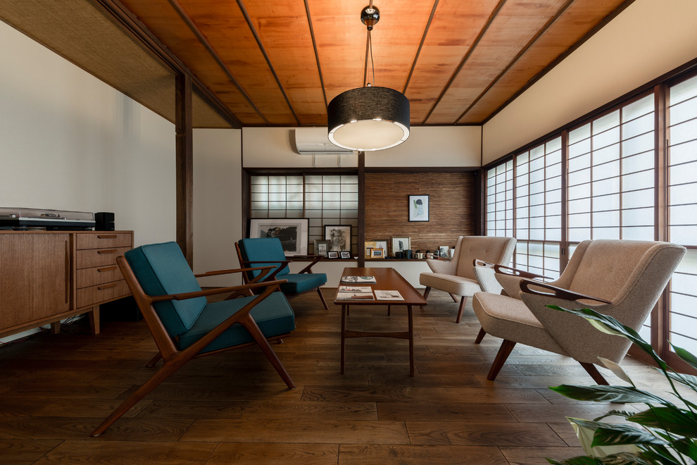 Immagine di un soggiorno etnico di medie dimensioni con pareti bianche, pavimento in legno massello medio e pavimento marrone