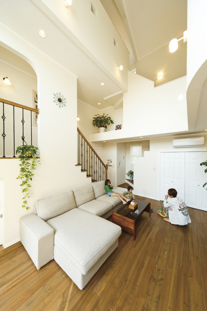 Mediterranes Wohnzimmer mit weißer Wandfarbe, braunem Holzboden und braunem Boden in Sonstige