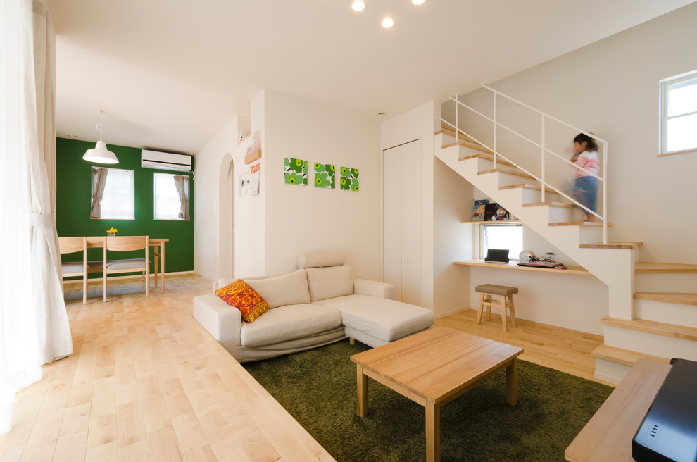 Diseño de salón para visitas abierto escandinavo sin chimenea con paredes blancas, suelo de madera clara y televisor independiente