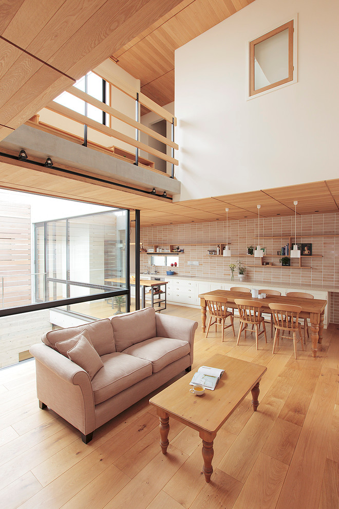 Example of a classic open concept medium tone wood floor living room design in Tokyo with white walls and no fireplace