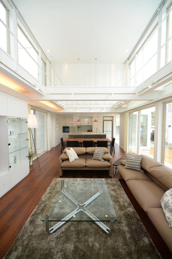 Foto di un soggiorno moderno aperto con pareti bianche, parquet scuro e pavimento marrone
