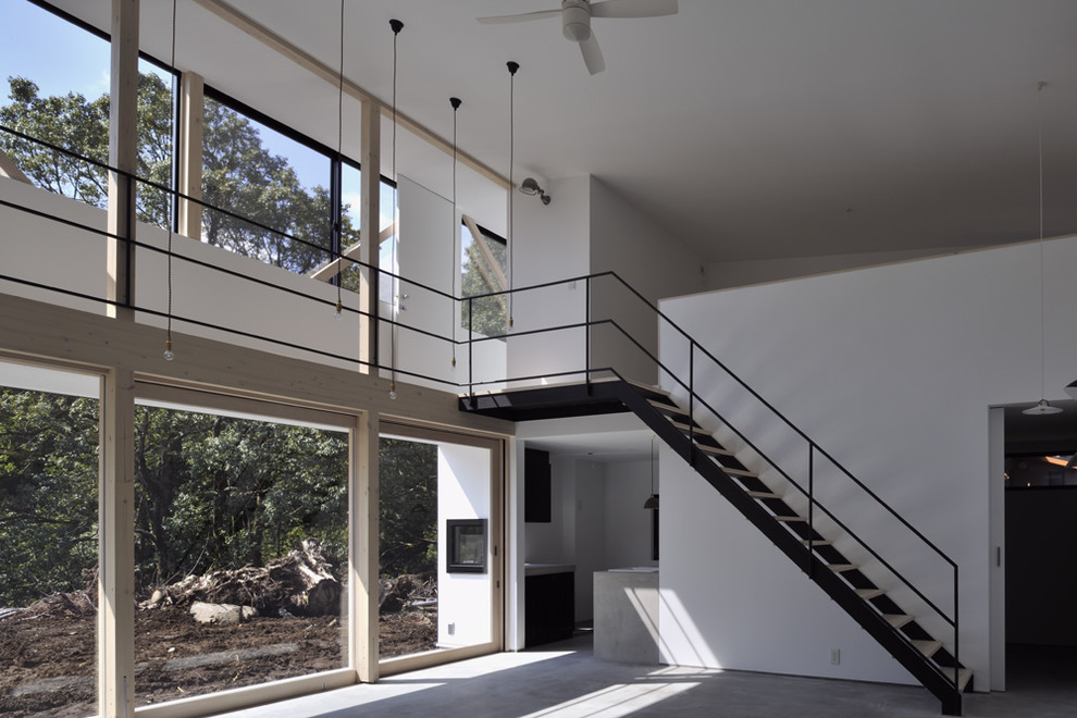 На фото: гостиная комната в стиле модернизм с белыми стенами, бетонным полом и серым полом без камина