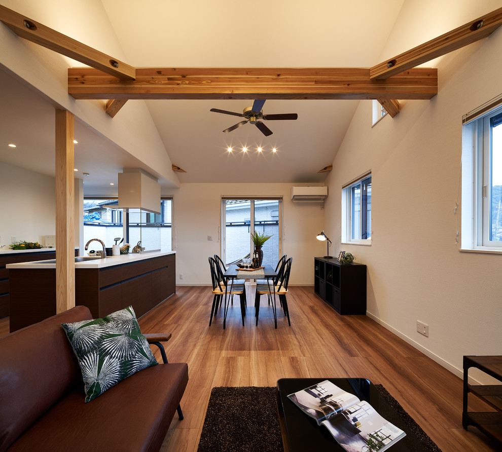 Imagen de salón abierto moderno de tamaño medio con paredes blancas, suelo de madera en tonos medios y suelo marrón