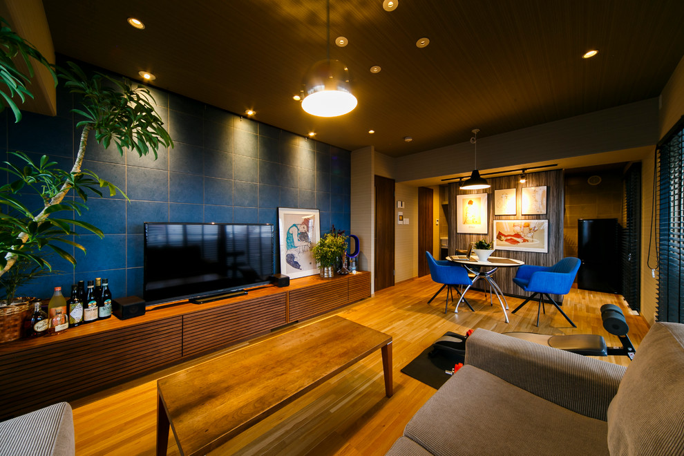 Exemple d'un salon tendance avec un mur beige, un sol en bois brun, aucune cheminée et un téléviseur indépendant.