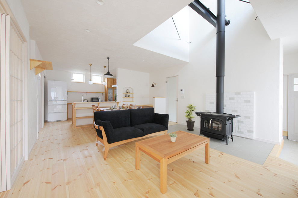 World-inspired open plan living room in Nagoya with white walls, light hardwood flooring and beige floors.