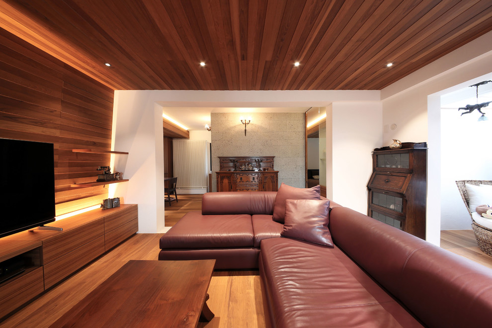 Modernes Wohnzimmer ohne Kamin mit weißer Wandfarbe, dunklem Holzboden, freistehendem TV und braunem Boden in Tokio
