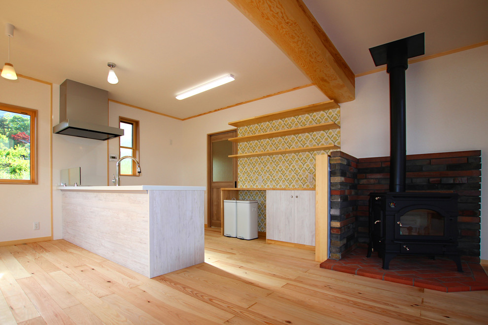 Aménagement d'un salon asiatique de taille moyenne et ouvert avec une salle de réception, un mur blanc, parquet clair, un poêle à bois, un manteau de cheminée en brique et un sol beige.