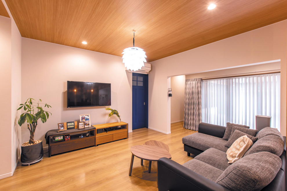 Inspiration för ett minimalistiskt allrum med öppen planlösning, med vita väggar, mellanmörkt trägolv, en väggmonterad TV och brunt golv
