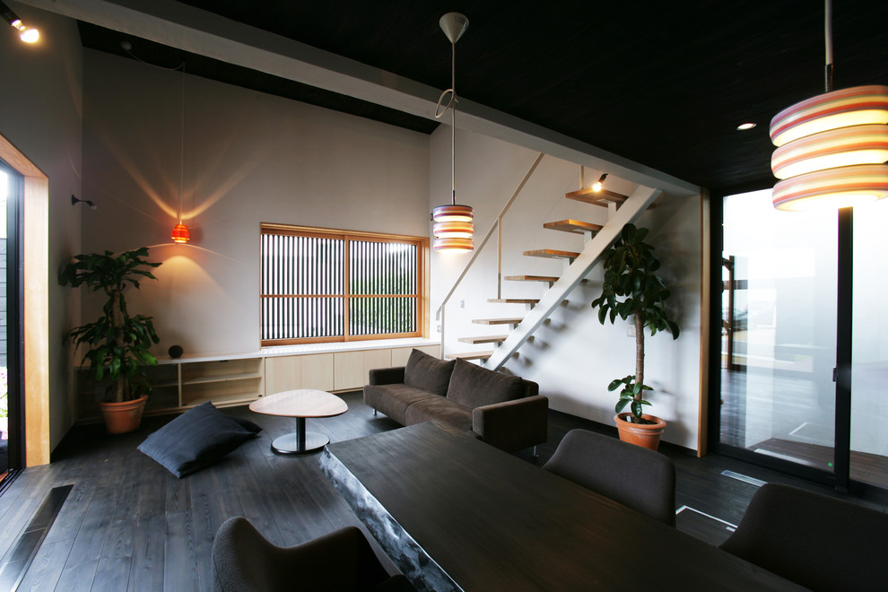 На фото: открытая гостиная комната в стиле модернизм с белыми стенами и деревянным полом с