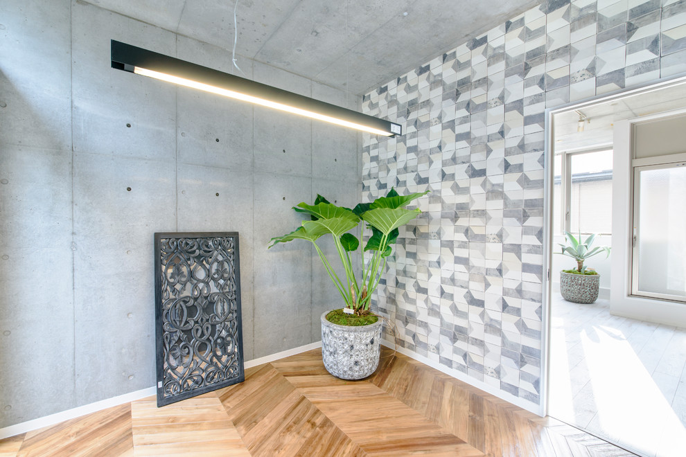 Diseño de salón abierto minimalista de tamaño medio con paredes grises, suelo de madera clara y suelo marrón