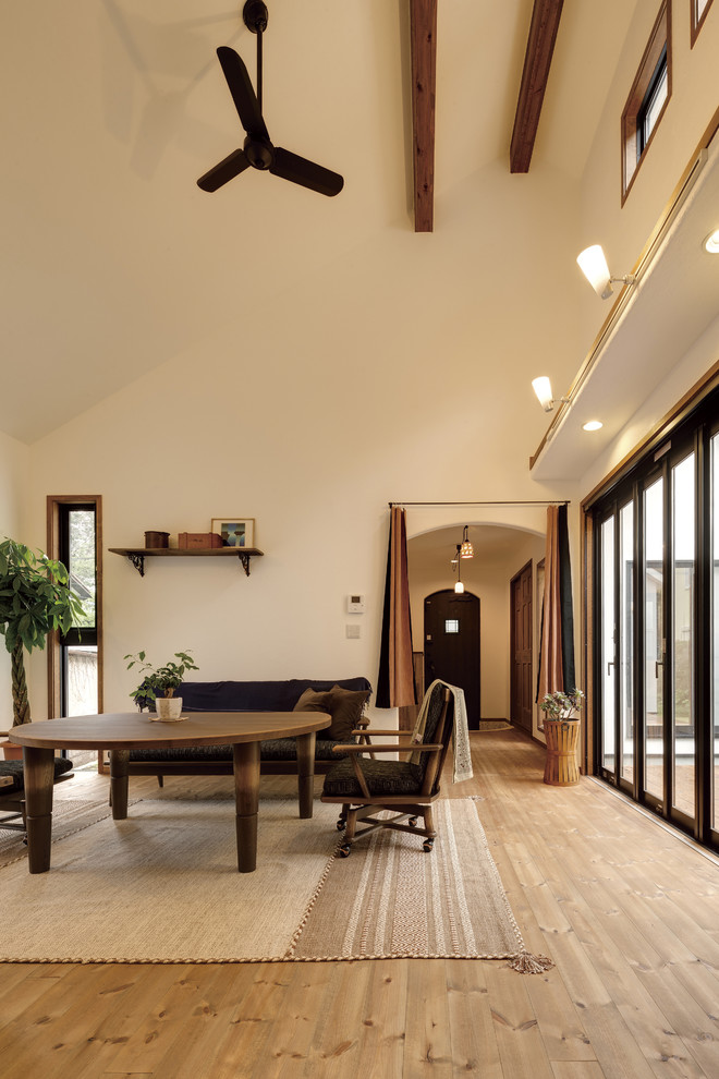 Farmhouse living room in Tokyo Suburbs with white walls, medium hardwood flooring and brown floors.