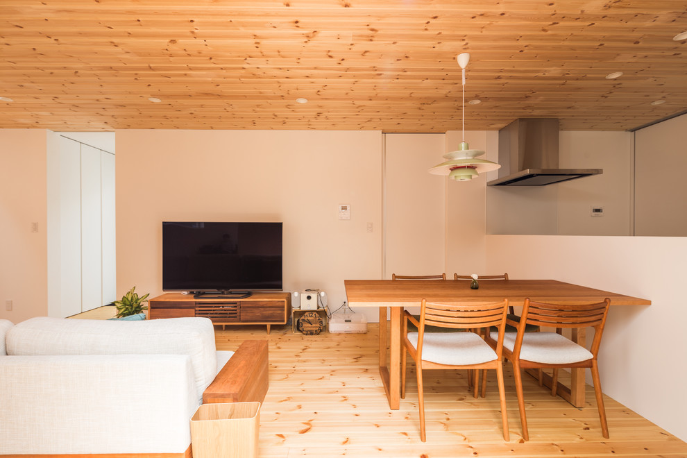 Foto di un grande soggiorno aperto con pareti bianche, pavimento in legno massello medio, nessun camino e TV autoportante