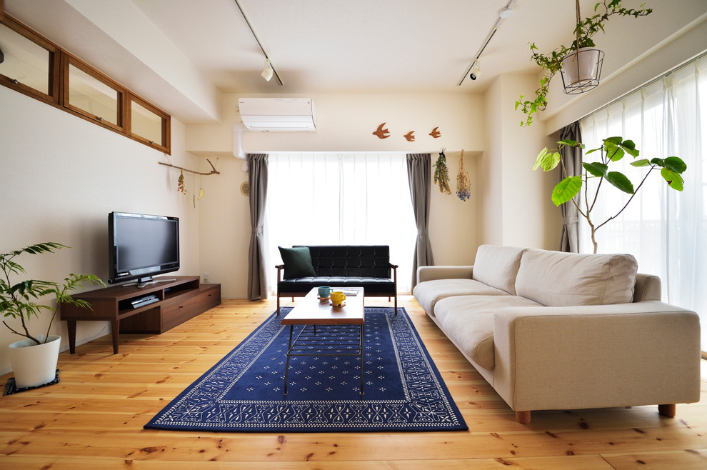 Ejemplo de salón nórdico con suelo de madera clara y televisor independiente