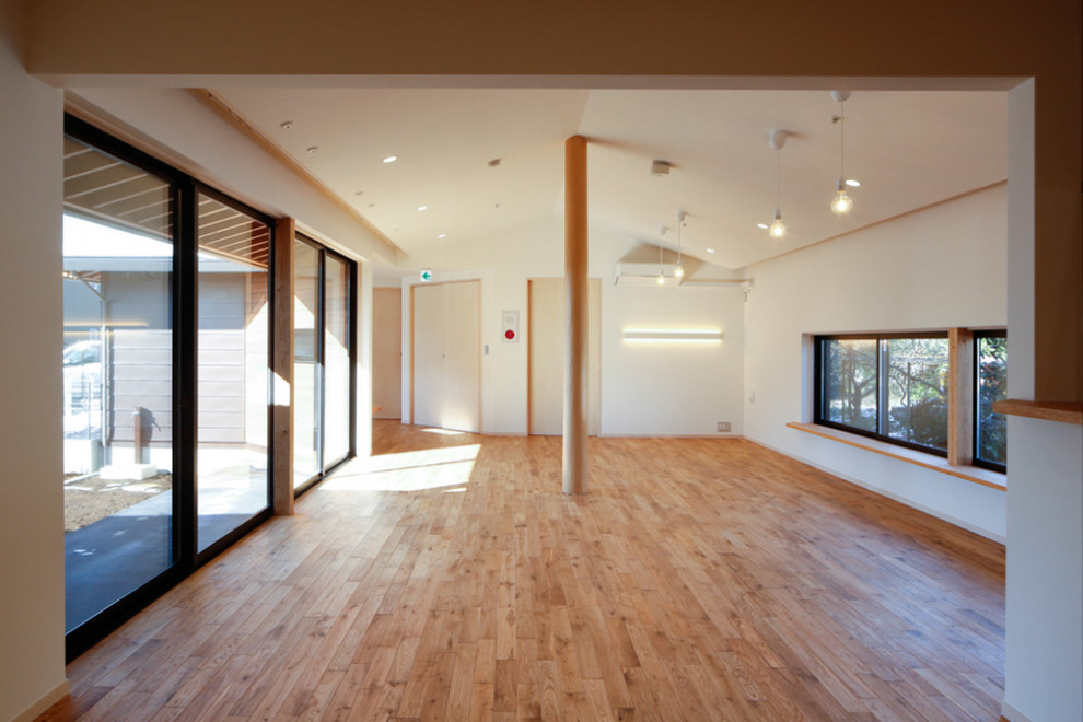 Ejemplo de salón abierto nórdico grande con paredes blancas y suelo de madera en tonos medios