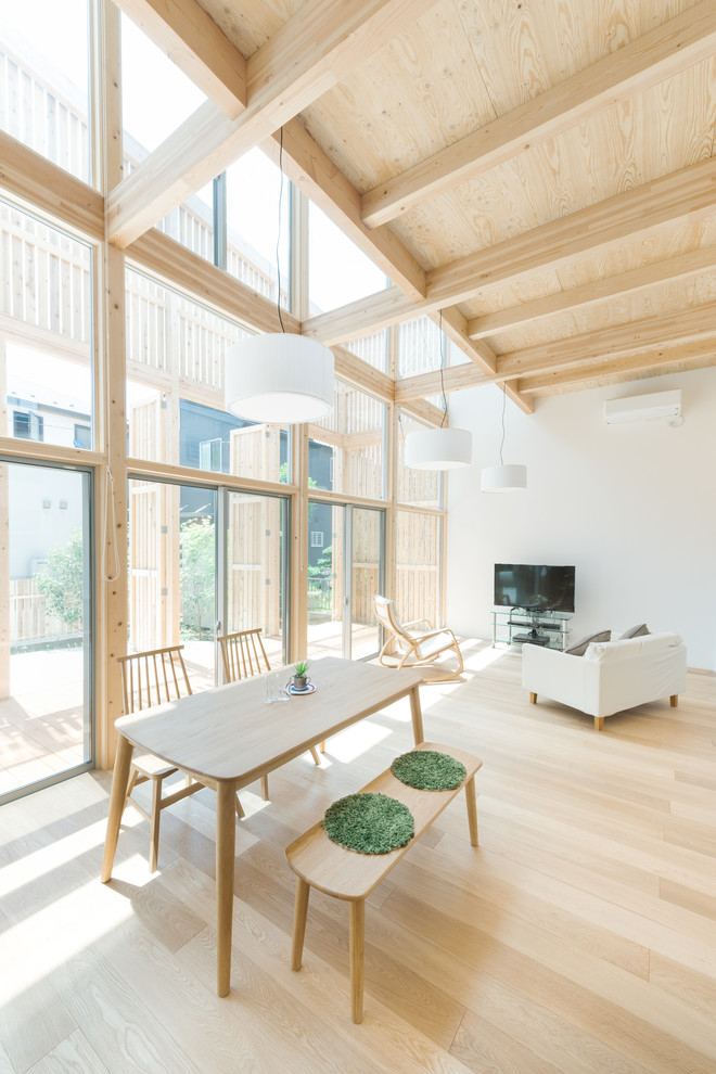 Immagine di un soggiorno etnico con pareti bianche, parquet chiaro, TV autoportante e pavimento beige