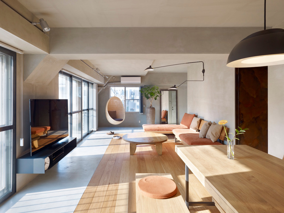 Repräsentatives, Offenes Nordisches Wohnzimmer ohne Kamin mit hellem Holzboden, freistehendem TV und grauer Wandfarbe in Sonstige