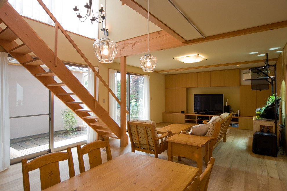 Medium tone wood floor and brown floor living room photo in Tokyo Suburbs with beige walls and a tv stand