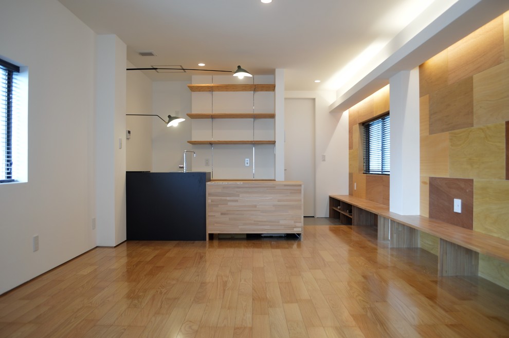 Mittelgroßes Mid-Century Wohnzimmer mit weißer Wandfarbe, braunem Holzboden, freistehendem TV und braunem Boden in Sonstige
