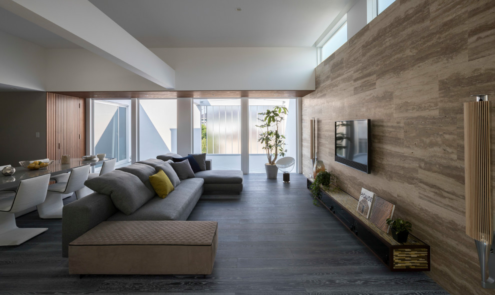 Idee per un grande soggiorno minimalista aperto con pareti marroni, pavimento in legno verniciato, TV a parete, pavimento grigio e nessun camino