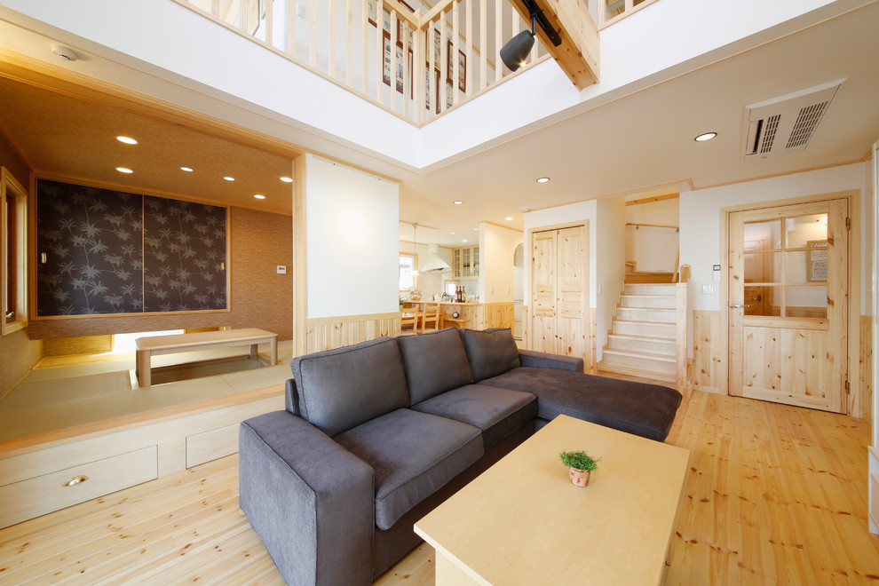 Scandi living room in Tokyo Suburbs with light hardwood flooring, white walls and brown floors.