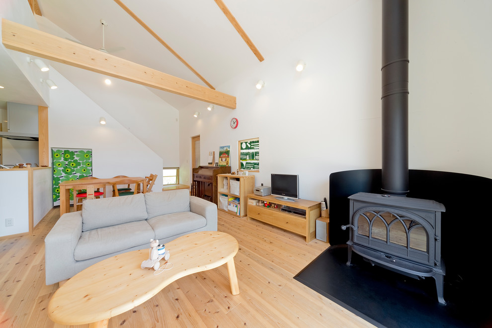 Источник вдохновения для домашнего уюта: открытая гостиная комната в скандинавском стиле с белыми стенами, светлым паркетным полом, отдельно стоящим телевизором и бежевым полом