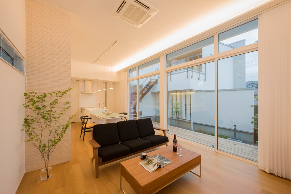 Foto de salón abierto de estilo zen pequeño con paredes blancas, suelo de madera en tonos medios y suelo marrón