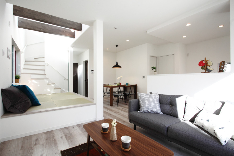 Esempio di un soggiorno minimal aperto con pareti bianche, pavimento in compensato e pavimento marrone