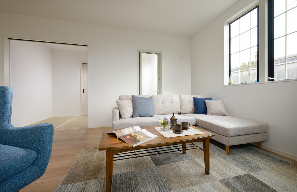Idee per un soggiorno etnico aperto con pareti bianche, pavimento in compensato e pavimento beige