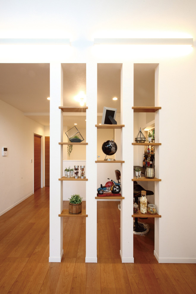 Bild på ett allrum med öppen planlösning, med vita väggar, plywoodgolv och brunt golv