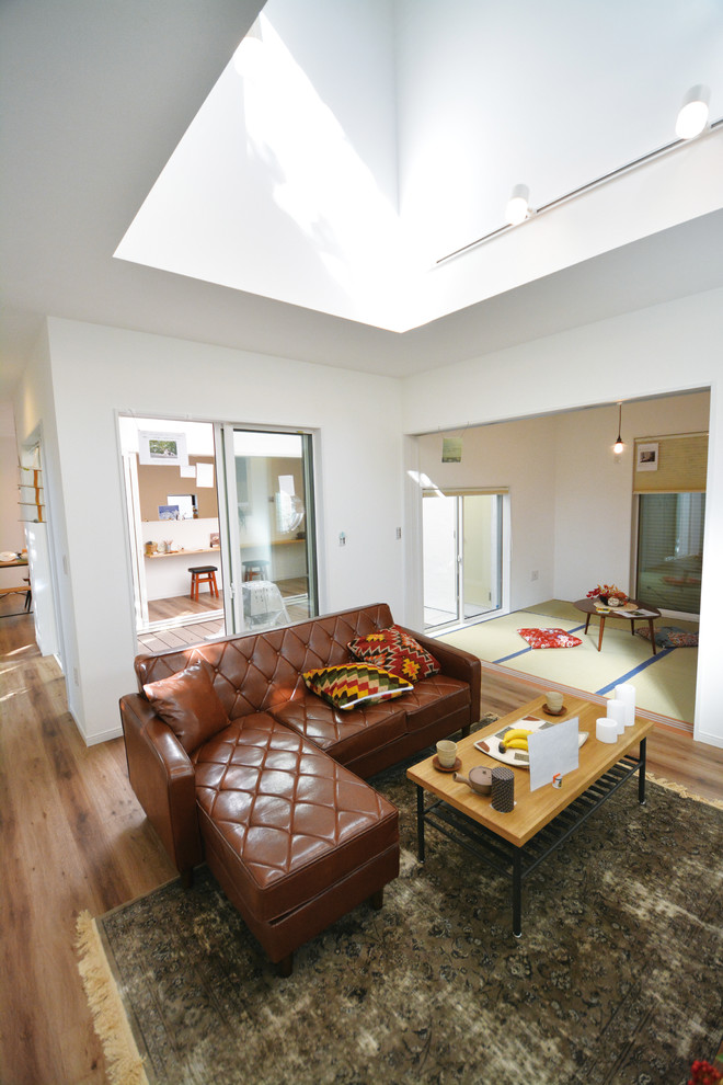 Idee per un soggiorno design aperto con pareti bianche, pavimento in compensato e pavimento marrone
