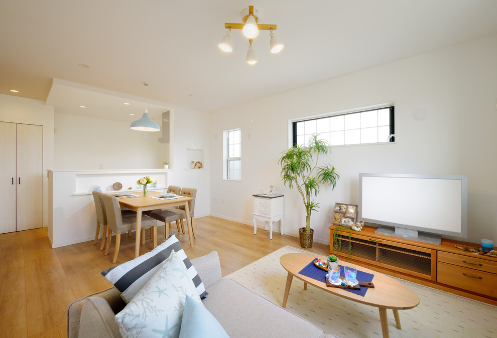 Modelo de salón abierto nórdico con paredes blancas, suelo de contrachapado, suelo beige y televisor independiente