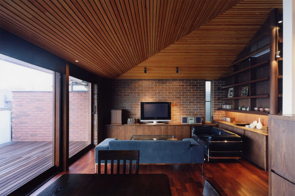 Mittelgroßes, Repräsentatives, Offenes Mid-Century Wohnzimmer ohne Kamin mit brauner Wandfarbe, dunklem Holzboden, freistehendem TV, braunem Boden, Holzdecke und Ziegelwänden in Tokio