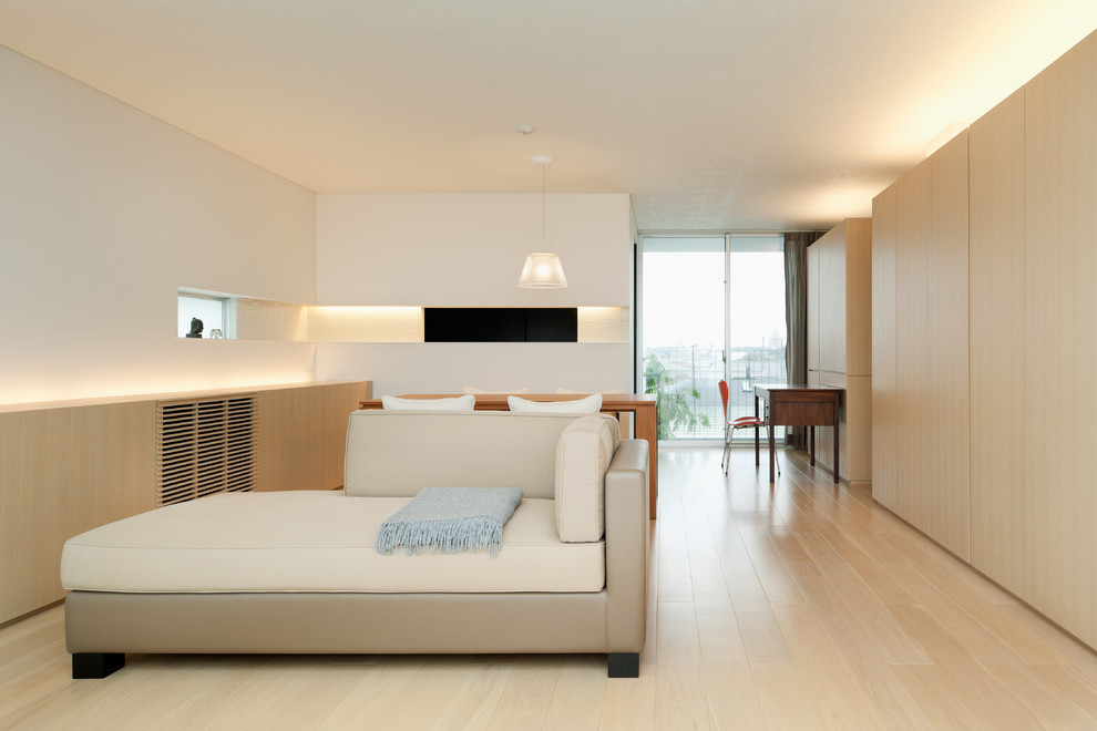 Immagine di un soggiorno etnico con pareti bianche, pavimento in legno verniciato e pavimento beige