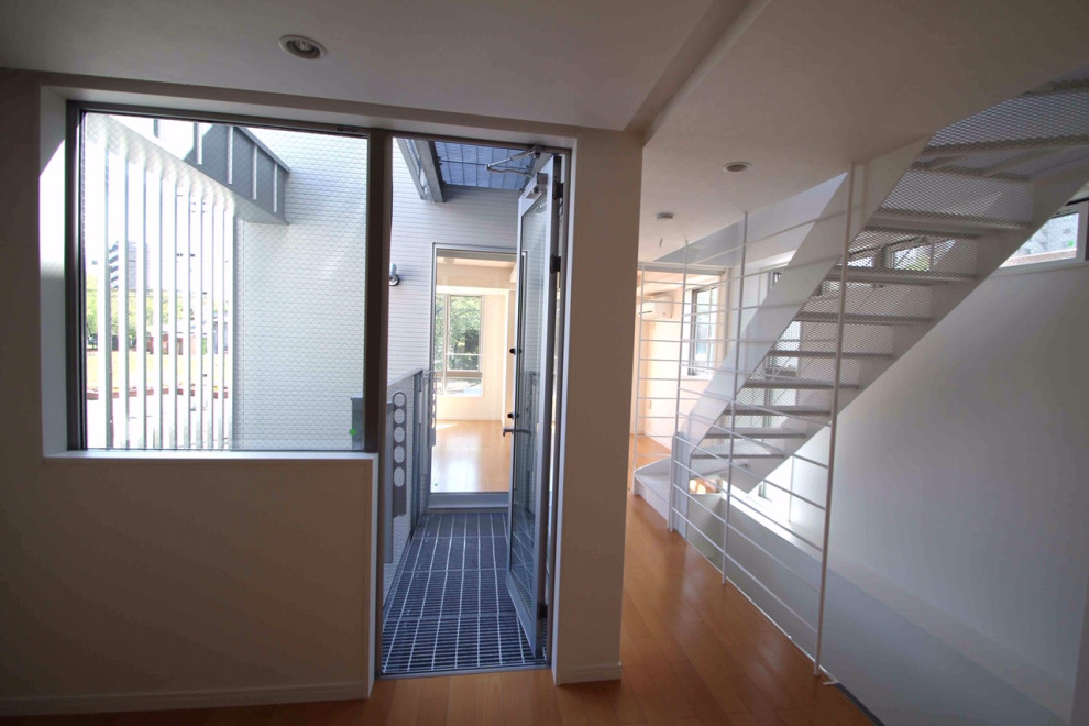 This is an example of a medium sized modern enclosed living room in Tokyo with white walls, light hardwood flooring, beige floors, a drop ceiling and wallpapered walls.