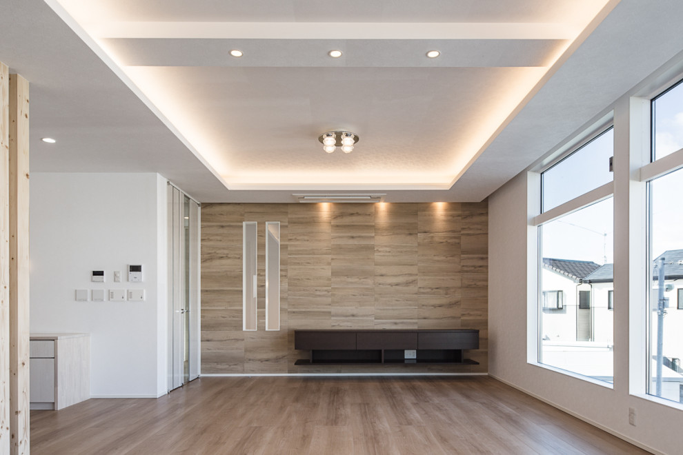 Ejemplo de salón abierto minimalista sin chimenea con paredes marrones, suelo de contrachapado, televisor independiente y suelo marrón